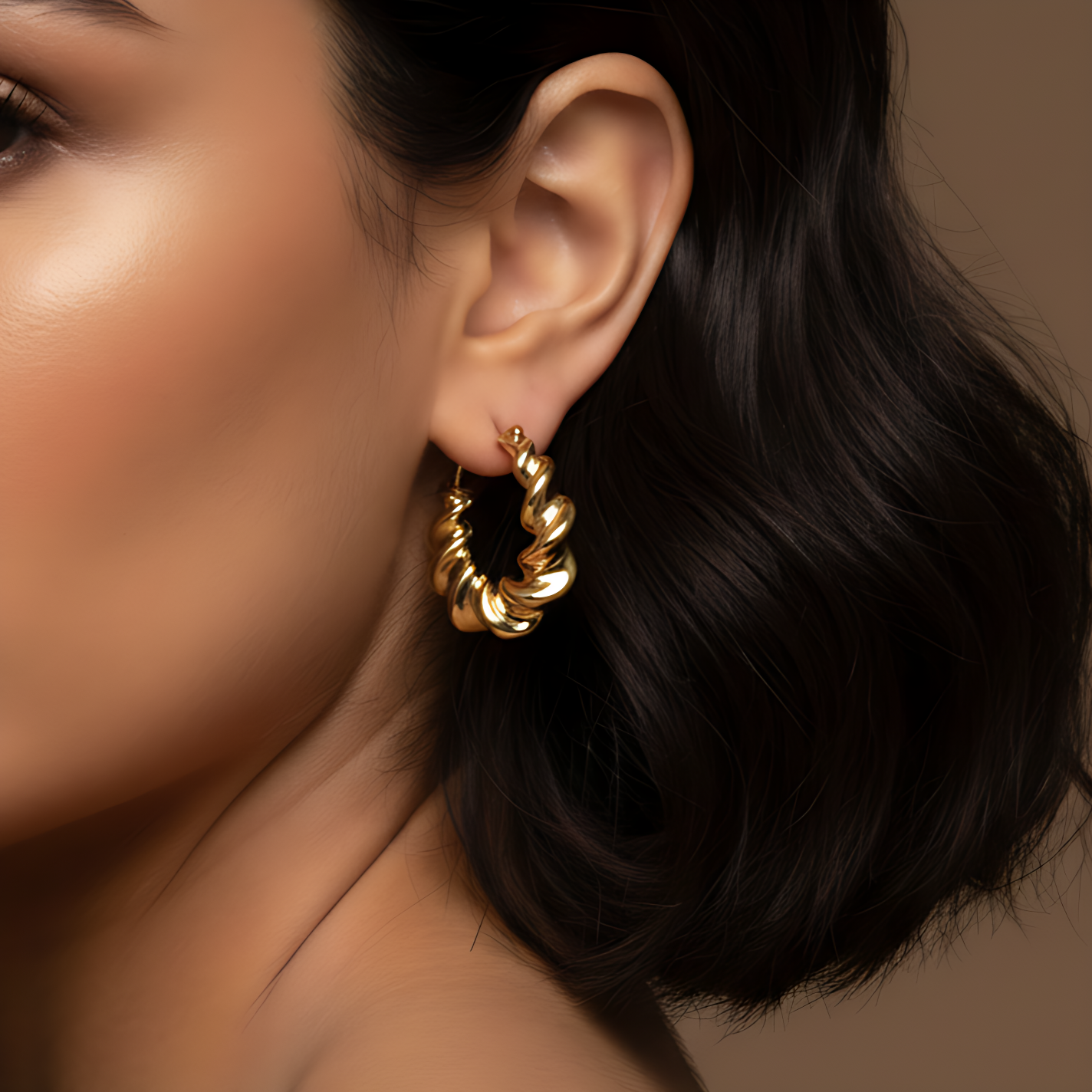 close up of gold earrings on model