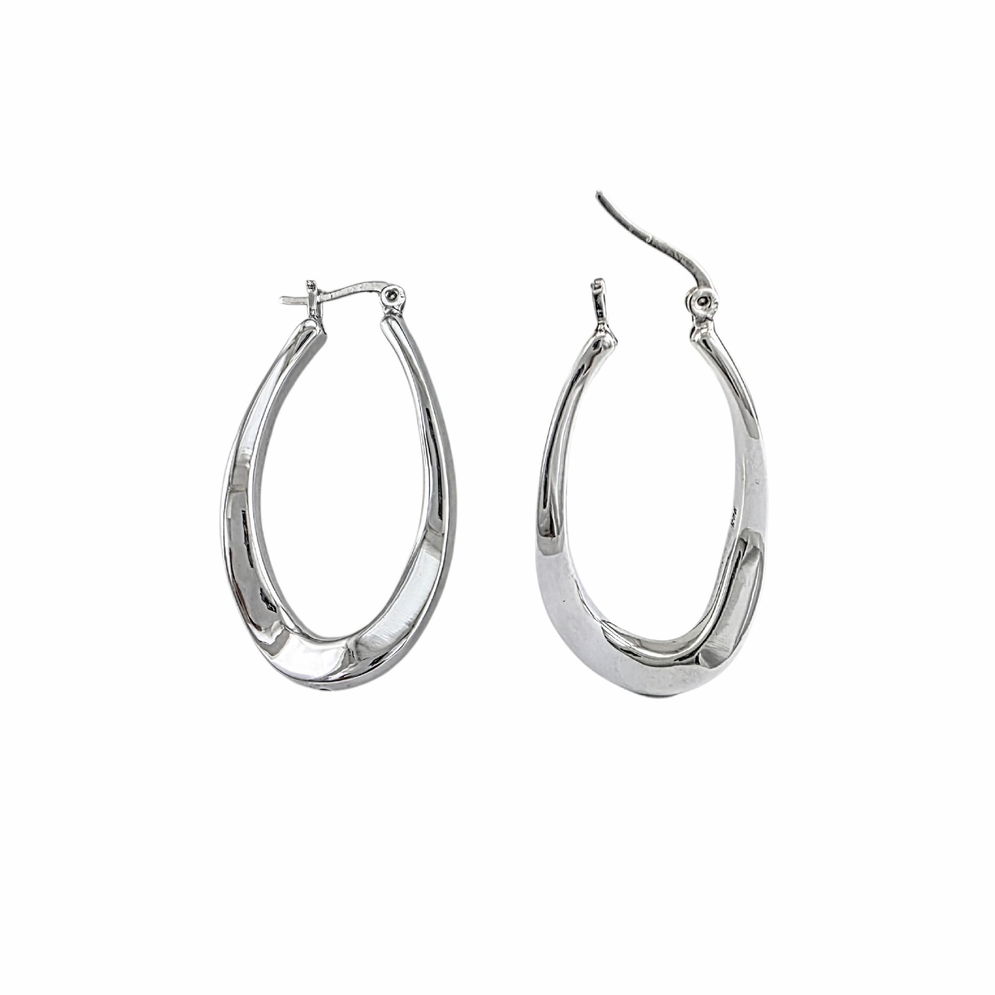 Paire de créoles ovales allongées torsadées en argent sterling 925 avec finition polie miroir et fermeture à charnière sur fond blanc