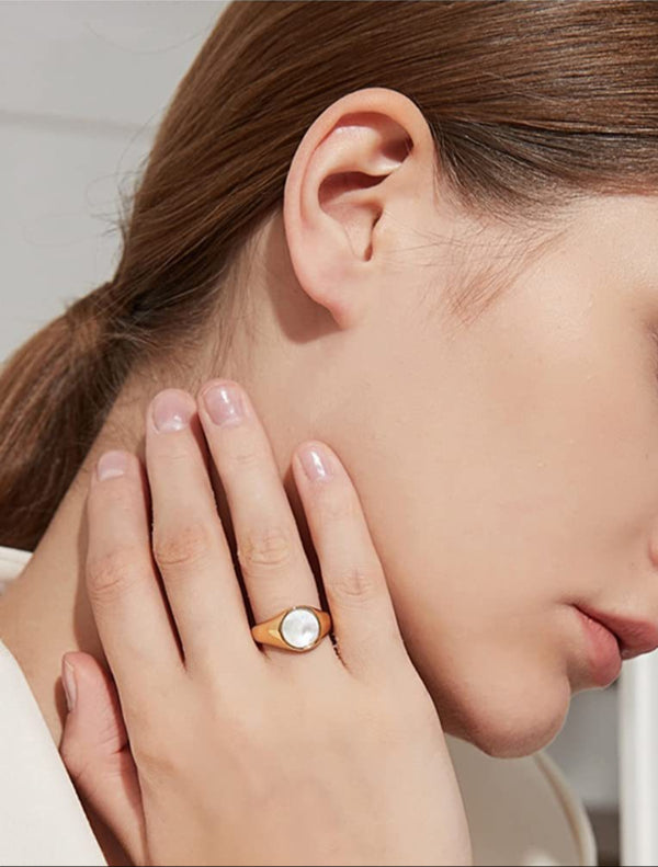 Bague chevalière dorée avec pierre ronde en nacre, style élégant et minimaliste