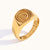 Bague dorée gravée en spirale avec motifs ethniques, présentée sur fond blanc