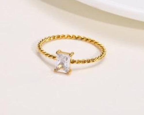 Bague dorée avec pierre zircon rectangulaire claire sur anneau torsadé, tailles 6 à 9