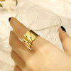 Bague dorée à larges maillons façon chaîne, posée sur fond blanc