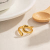  Bague dorée au design courbé et sculptural, avec finition lisse et brillante, présentée sur fond blanc