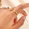 Bague dorée minimaliste ondulée en forme de vague, vue de face sur fond blanc