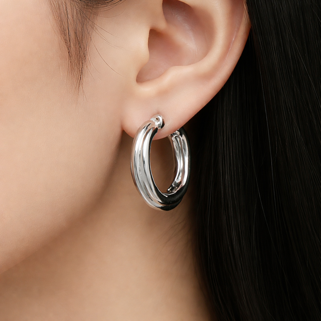 Paire de créoles rondes torsadées en argent sterling 925 avec finition polie et fermeture à charnière sur fond blanc