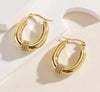 Boucles d’oreilles dorées ovales à double afond clairnneau avec tressage central, posées sur 