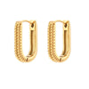Boucles d’oreilles dorées rectangulaires nervurées, posées sur fond blanc