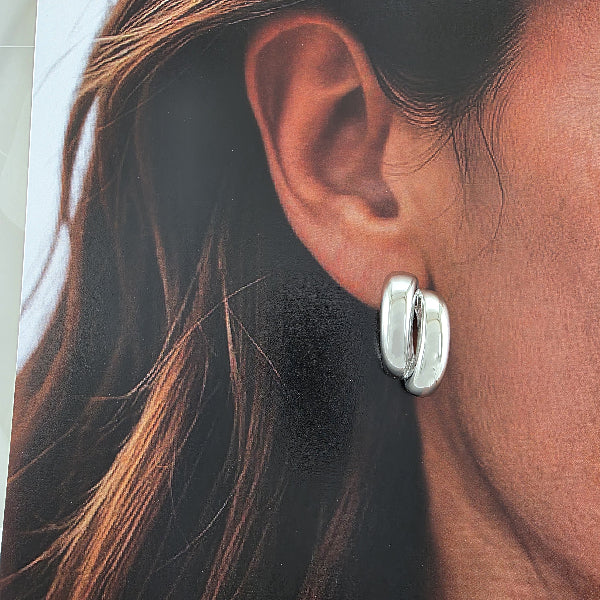 Boucle d’oreille dorée bombée à double arc, vue de face, fond blanc
