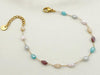 Bracelet doré fin avec perles multicolores facettées, chaîne ajustable et fermoir mousqueton.