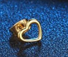 Clou d’oreille doré en forme de cœur ouvert sur fond bleu pailleté