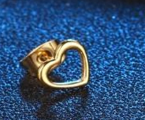 Clou d’oreille doré en forme de cœur ouvert sur fond bleu pailleté