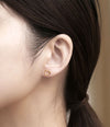 Clou d’oreille doré en forme de cœur ouvert sur fond bleu pailleté
