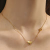 Collier doré avec pendentif en forme de cœur et petite clé assortie, présenté sur fond blanc