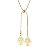 Collier doré avec deux pendentifs hamsa superposés, symbole protecteur, présenté sur fond blanc