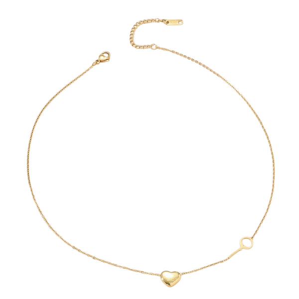 Collier doré avec pendentif en forme de cœur et petite clé assortie, présenté sur fond blanc