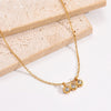 Collier doré avec trois zirconias alignés sur une chaîne fine, présenté sur fond blanc