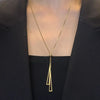 Collier doré 18k avec double pendentif triangle ajouré suspendu à une chaîne fine avec bille centrale.