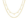 Collier doré à deux rangs avec petits pendentifs carrés, style délicat et moderne, présenté sur fond blanc