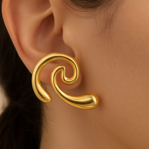 Boucle d’oreille dorée sculpturale en forme de vague portée à l’oreille, design fluide et moderne de la collection Élan Doré.