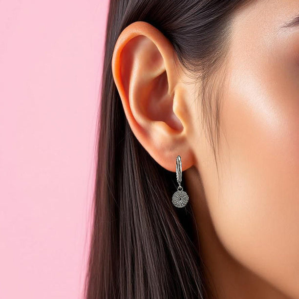 Huggies en acier inoxydable argent avec pendentif soleil gravé.