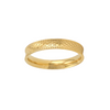 Bague fine dorée avec texture géométrique en relief, posée sur fond clair
