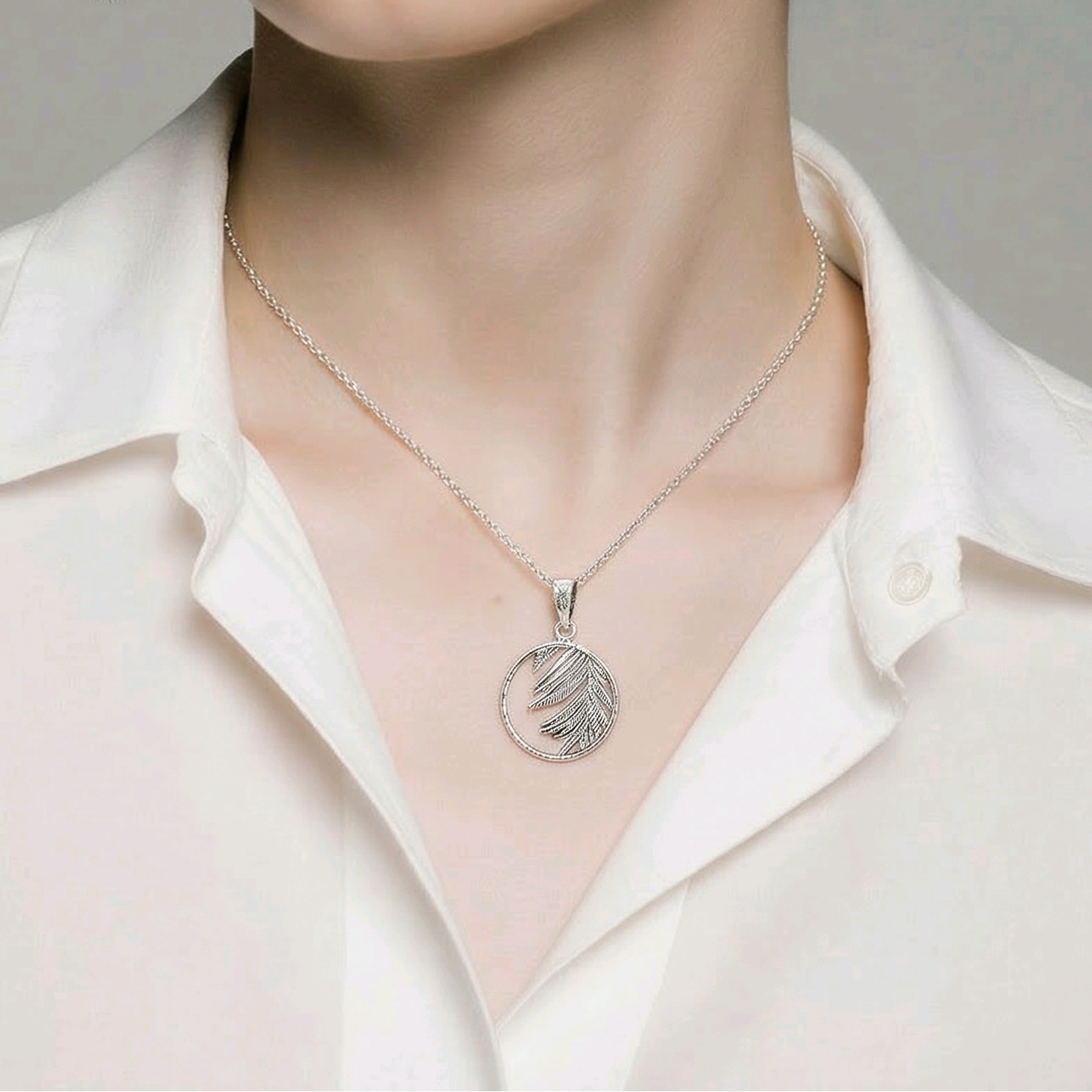 Pendentif rond ajouré en argent sterling 925 oxydé avec feuille de palmier gravée en relief débordant du cercle, 17mm, fond blanc