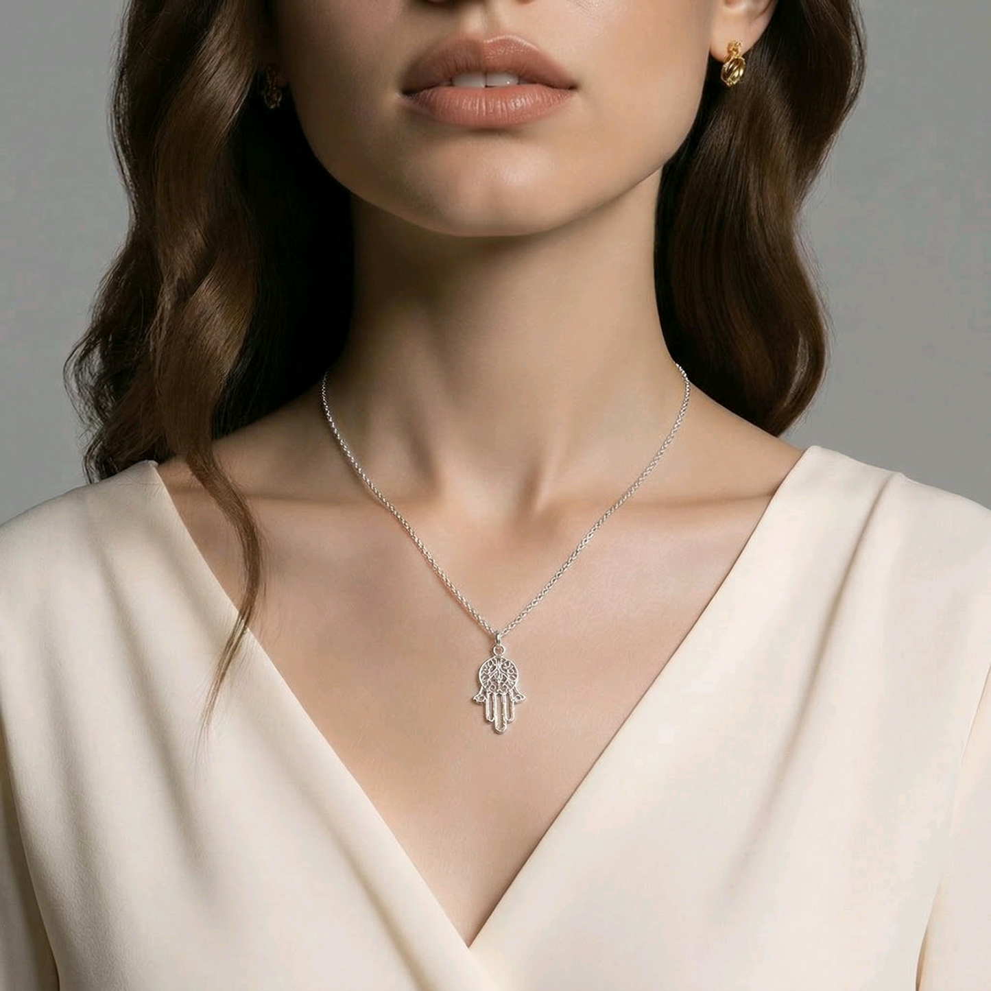 Pendentif hamsa main de Fatima ajourée en argent sterling 925 poli, médaillon central orné d'arabesques ciselées et doigts effilés, 28x17mm, fond blanc