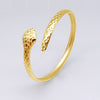 Bangle doré ouvert en forme de serpent avec texture écailles, sur fond blanc