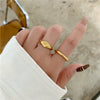 Bague signet dorée avec motif étoile du nord gravé, au style raffiné, présentée sur fond blanc
