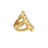 Bague longue dorée à effet spirale superposée, posée sur fond clair