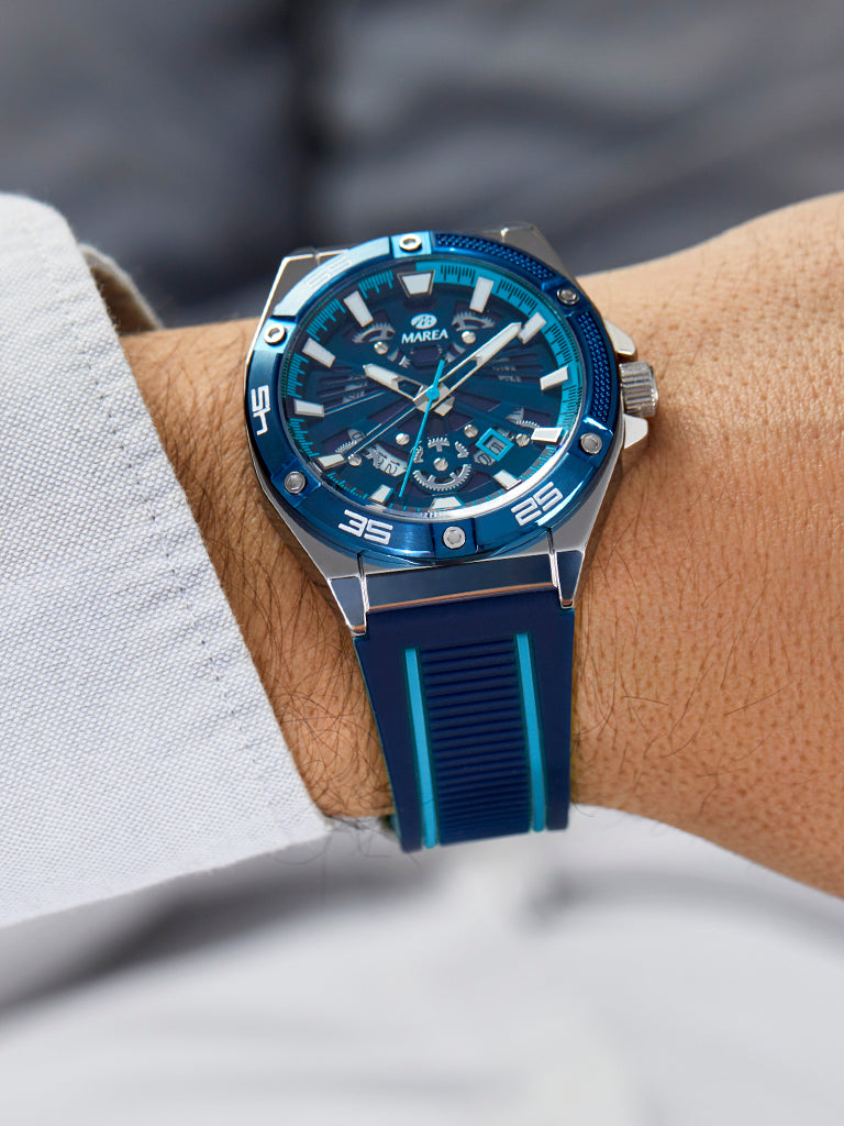 Vue de profil de la montre Marea en acier, couronne et lunette bleue à vis · EN: Side view of the Marea steel watch, crown and blue screw bezel