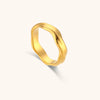 Bague dorée minimaliste ondulée en forme de vague, vue de face sur fond blanc