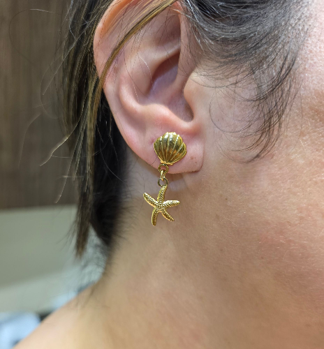 Boucles pendantes dorées en forme de coquillage et étoile de mer vue de face